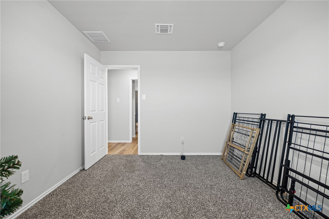 7203 Gilbert Drive Killeen, TX 76549 - Photo 11 of 16 an empty room with mirror and stairs