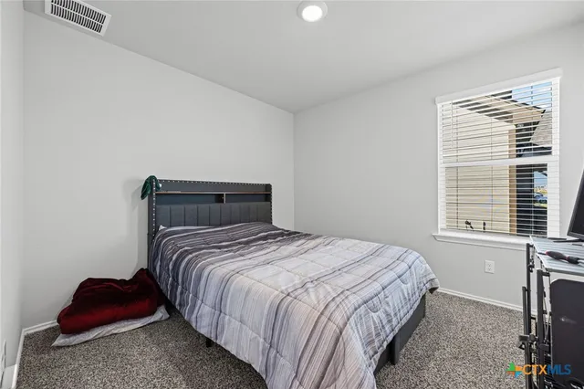 a bedroom with bed and a window