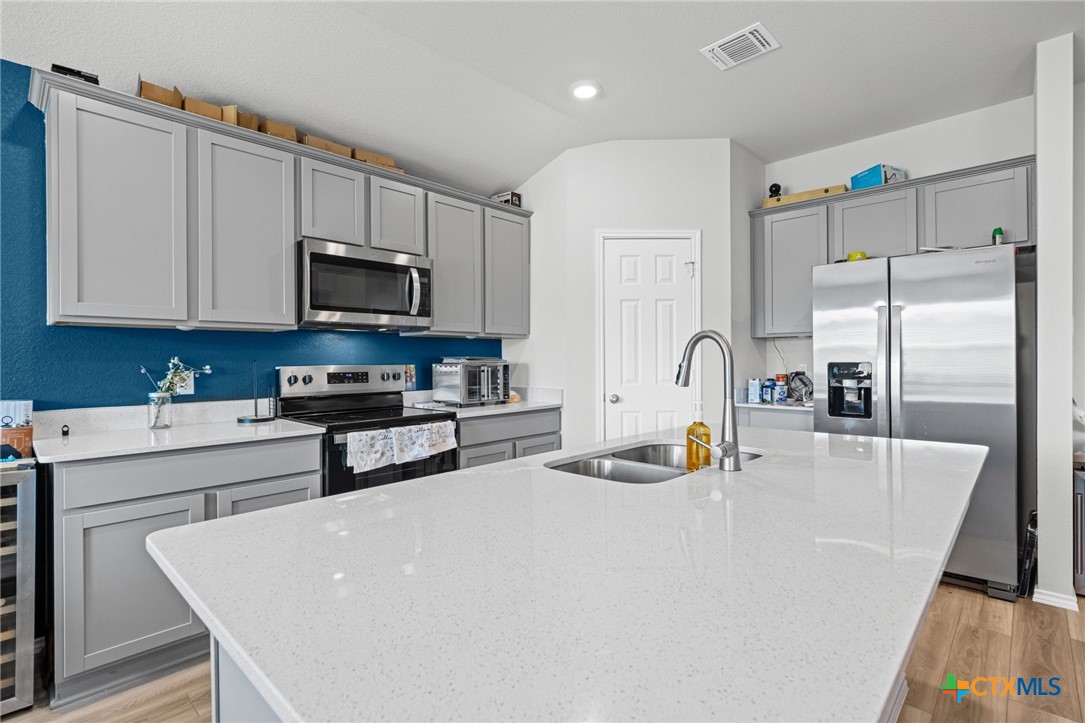 7203 Gilbert Drive Killeen, TX 76549 - Photo 6 of 16 a kitchen with stainless steel appliances a stove a refrigerator a sink a stove with white cabinets