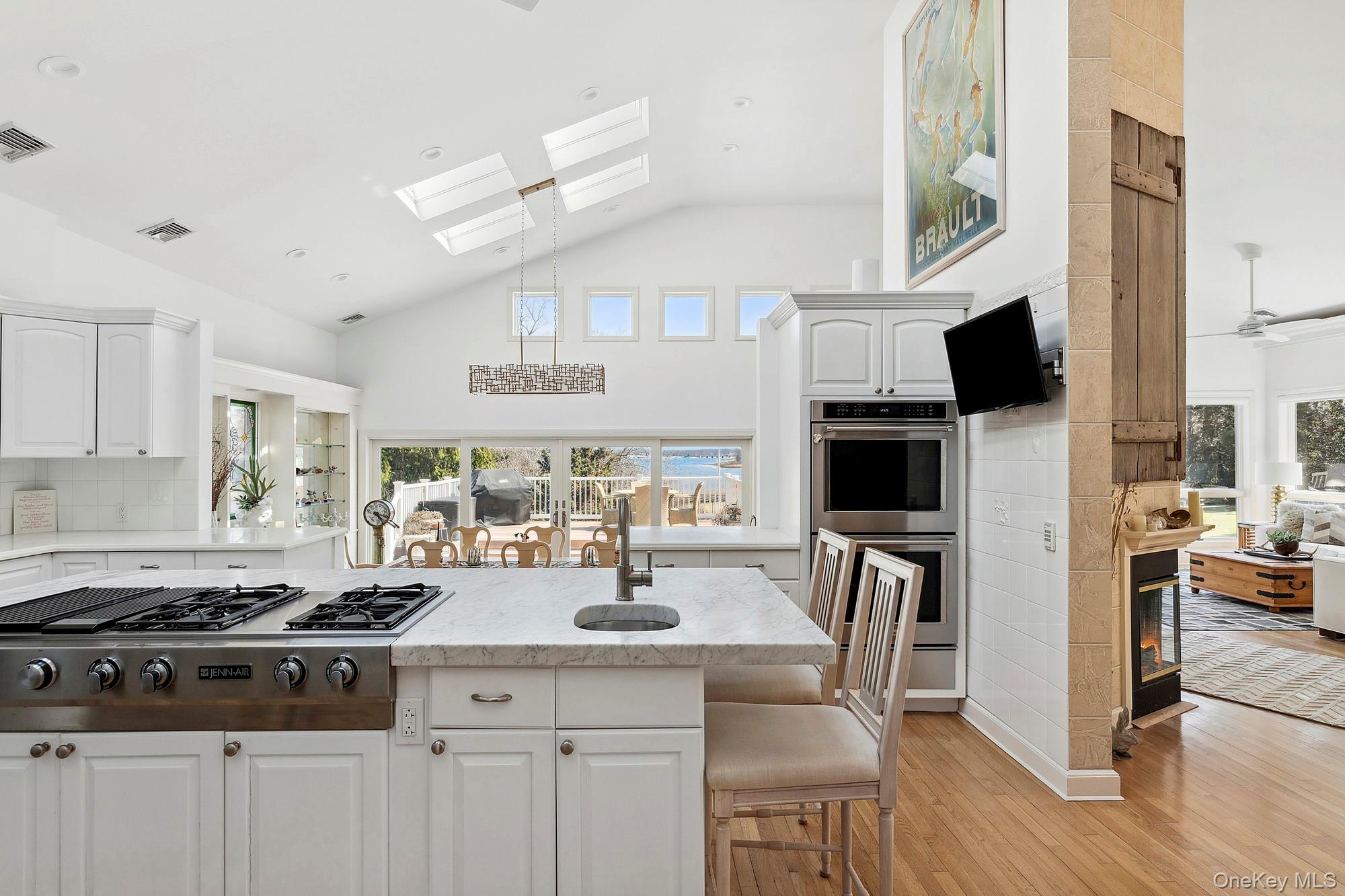 61 Factory Pond Road Locust Valley, NY 11560 - Photo 13 of 35 a kitchen with stainless steel appliances granite countertop a stove top oven a sink a dining table and chairs with wooden floor