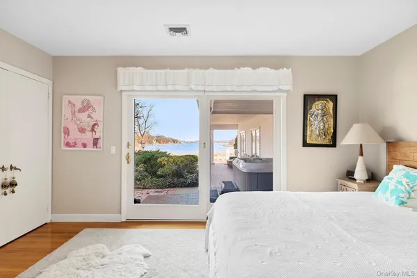 a bedroom with a bed painting on wall and a large window
