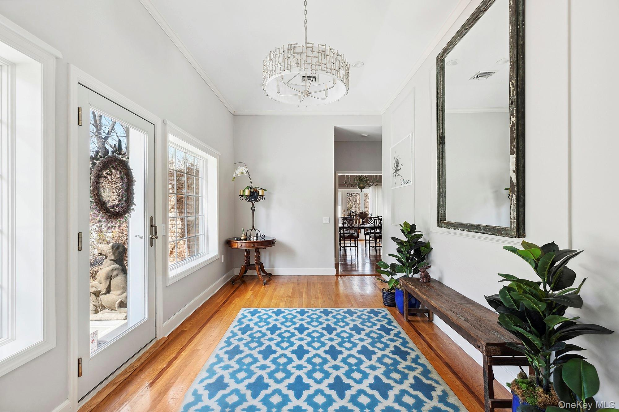 61 Factory Pond Road Locust Valley, NY 11560 - Photo 7 of 35 a hallway with wooden floor and a potted plant