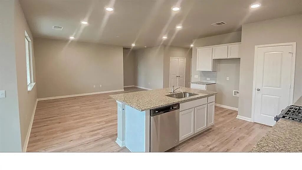 10612 Gonzales Ranger Pass Austin, TX 78754 - Photo 3 of 19 Granite countertops and recessed lighting define this airy, open-concept kitchen and living area.