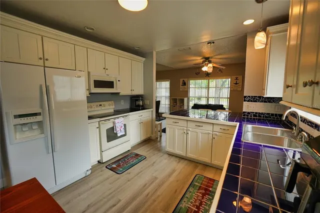 a kitchen with white cabinets and white appliances