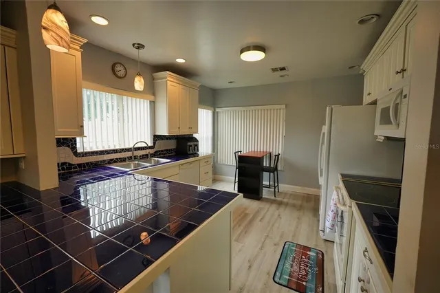 a kitchen with stainless steel appliances a sink a stove a refrigerator and cabinets