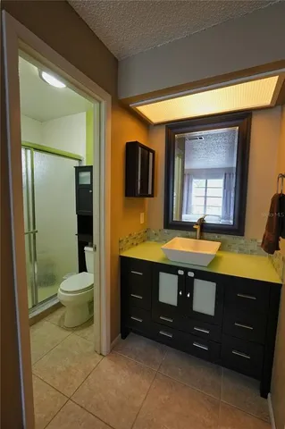 a spacious bathroom with a granite countertop sink toilet and mirror