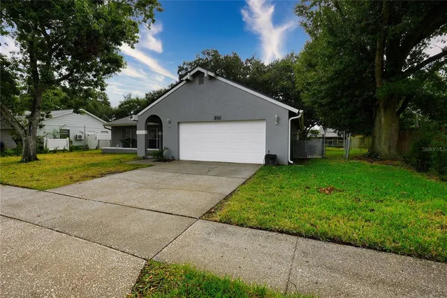 a view of a house with a yard and large tree