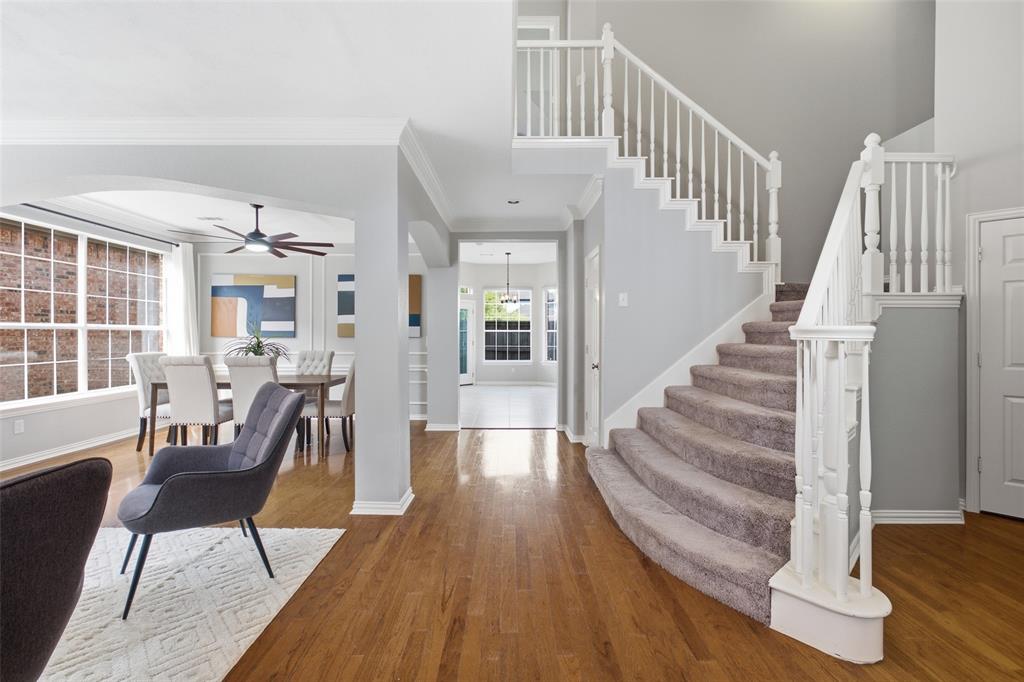 3903 Rive Lane Addison, TX 75001 - Photo 9 of 40 The two-story entry makes an immediate impression with its sweeping carpeted staircase, white spindle railing, and gleaming hardwood floors. Arched openings lead to the formal dining room and the study beyond, setting a sophisticated tone from the moment you walk in.