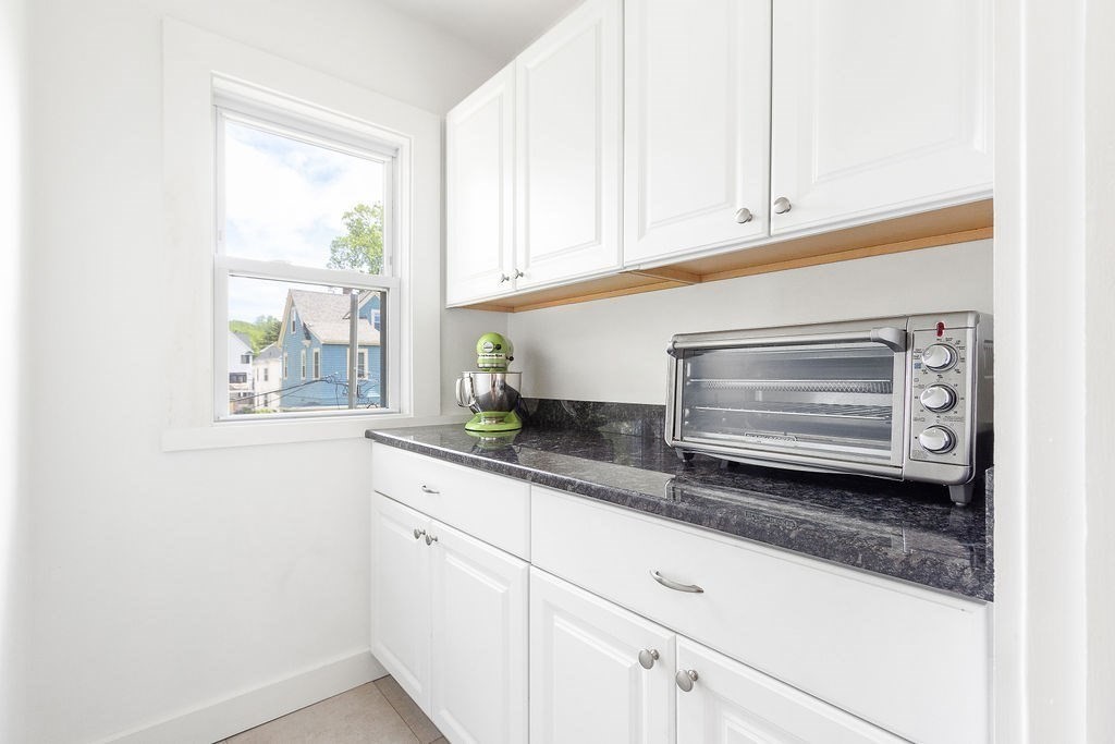 43 Sheffield Road, Unit 2 Boston, MA 02131 - Photo 4 of 16 a kitchen with granite countertop white cabinets and a window