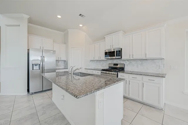 a kitchen with granite countertop a sink stove and refrigerator