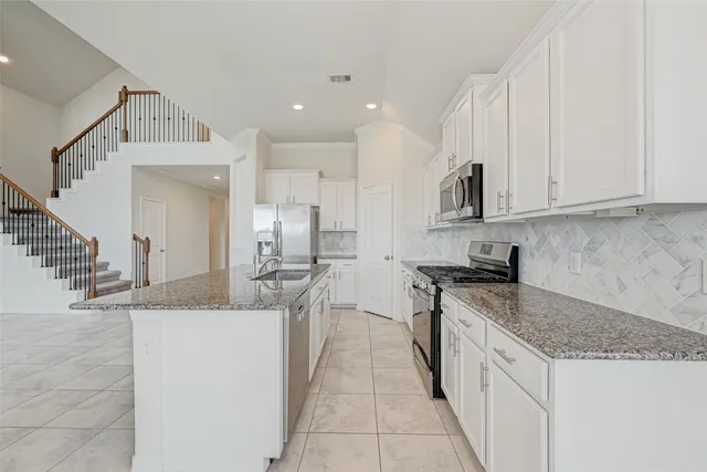 a kitchen with stainless steel appliances granite countertop a sink and cabinets