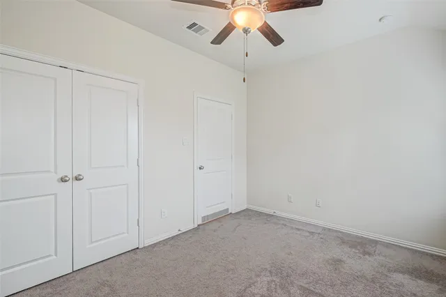 an empty room with a chandelier fan