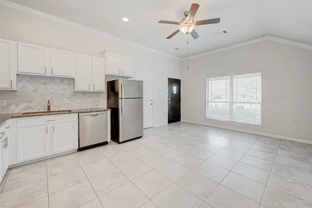 a kitchen with a refrigerator a sink and cabinets