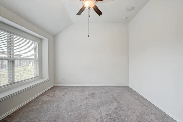 an empty room with a ceiling fan and window