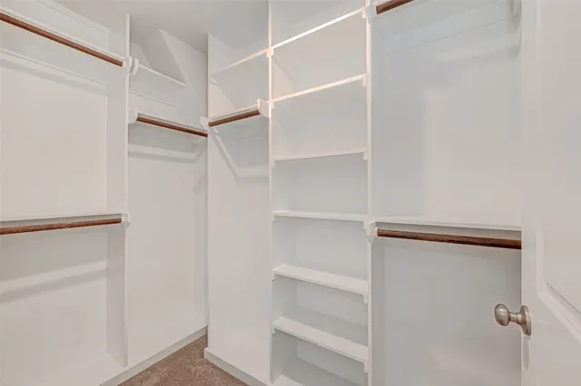 a view of walk in closet with empty racks
