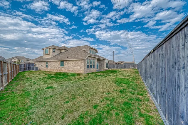 a view of a house with a small yard plants and large tree