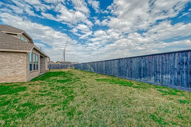 a view of a backyard with wooden fence