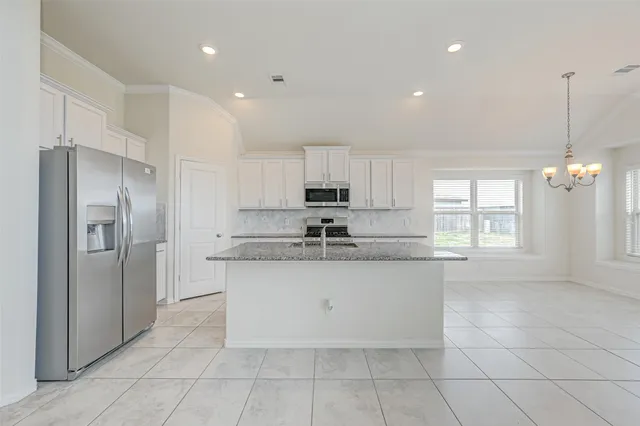 a large kitchen with stainless steel appliances granite countertop a sink and cabinets