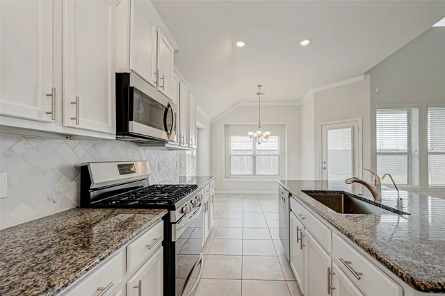 a kitchen with stainless steel appliances granite countertop a sink stove and cabinets