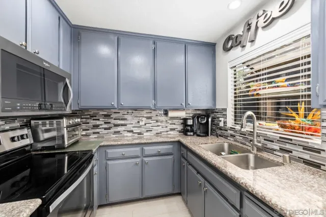 a kitchen with a sink and stainless steel appliances