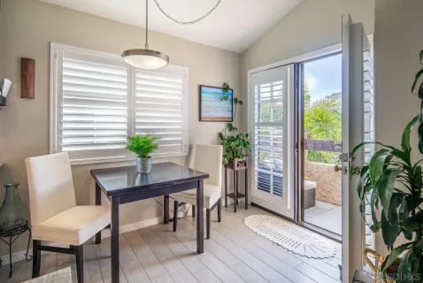 a dining room with furniture potted plants and wooden floor