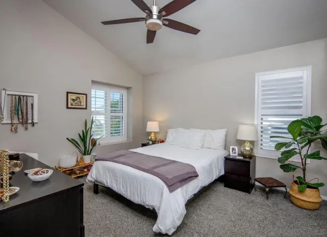 a bedroom with a bed a window and a flat screen tv