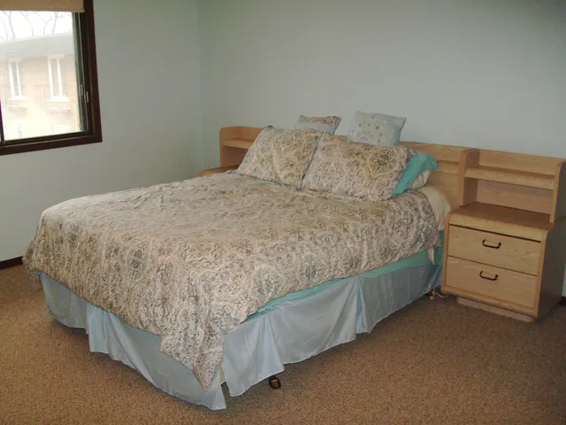 a bed sitting in a bedroom next to a window