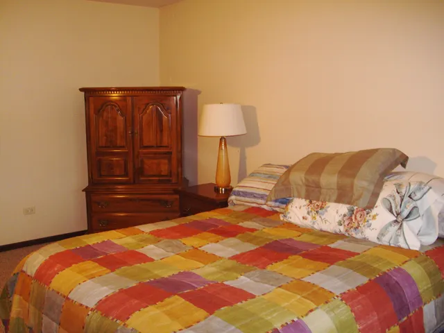 a bedroom with a bed and a lamp