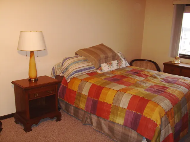 a bedroom with a bed and a lamp