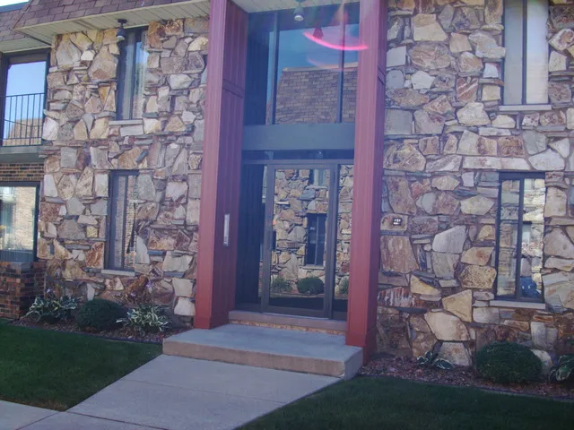 a front view of a brick building with a yard