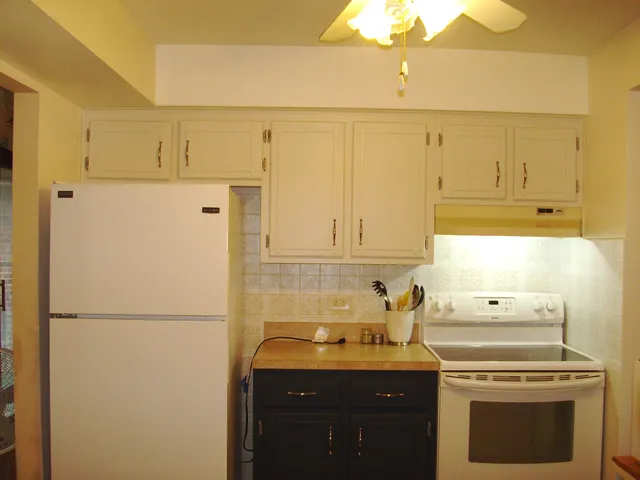 a kitchen with a refrigerator sink stove and cabinets