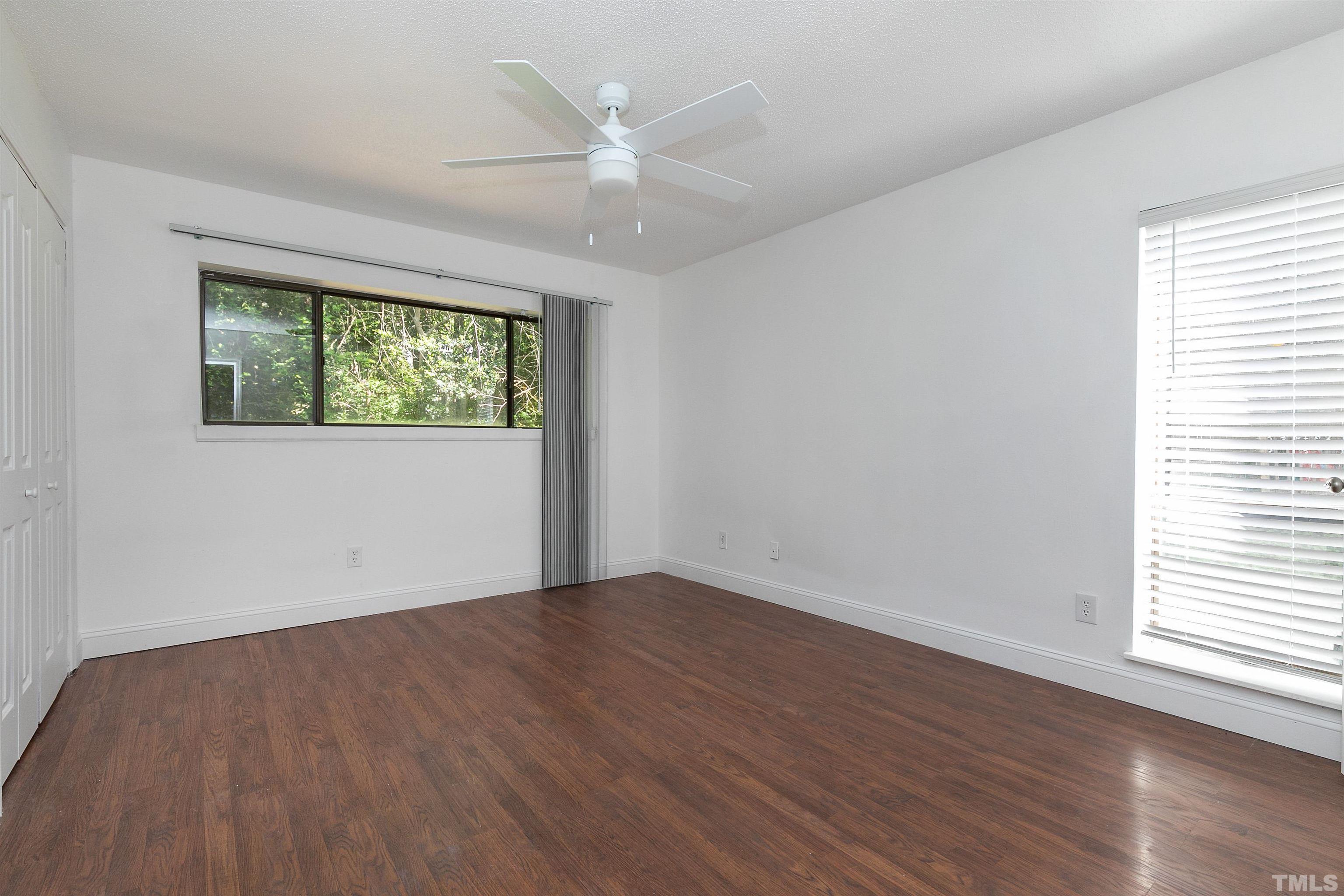 541 Pine Ridge Place, Unit 541 Raleigh, NC 27609 - Photo 15 of 21 an empty room with wooden floor chandelier fan and windows