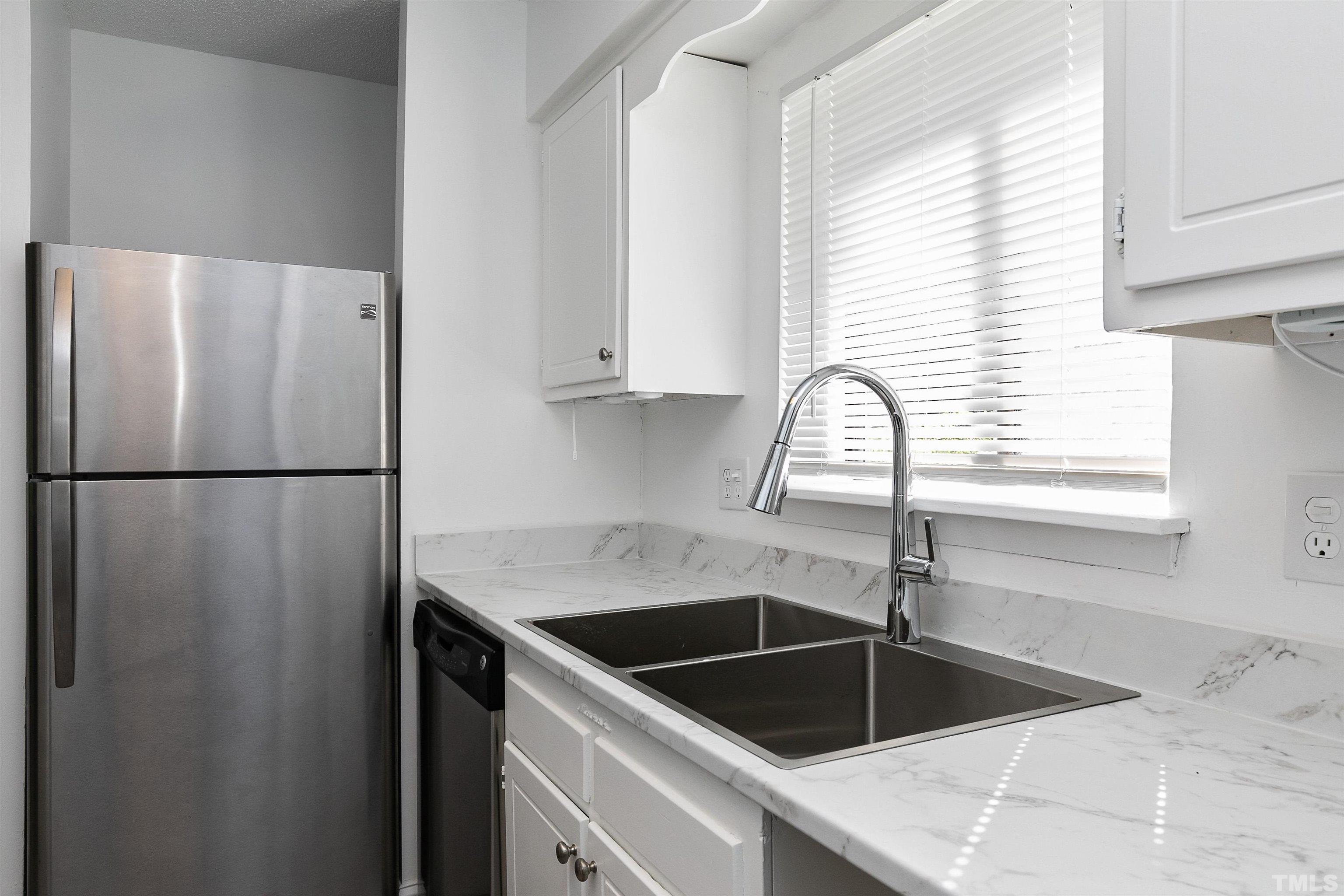 541 Pine Ridge Place, Unit 541 Raleigh, NC 27609 - Photo 4 of 21 a kitchen with a refrigerator sink and cabinets