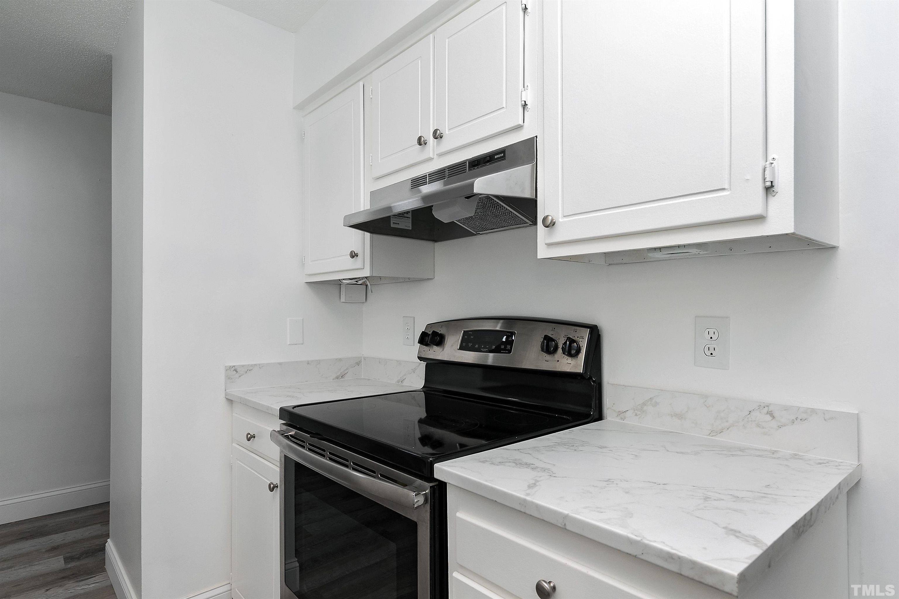 541 Pine Ridge Place, Unit 541 Raleigh, NC 27609 - Photo 5 of 21 a kitchen with a stove and a microwave
