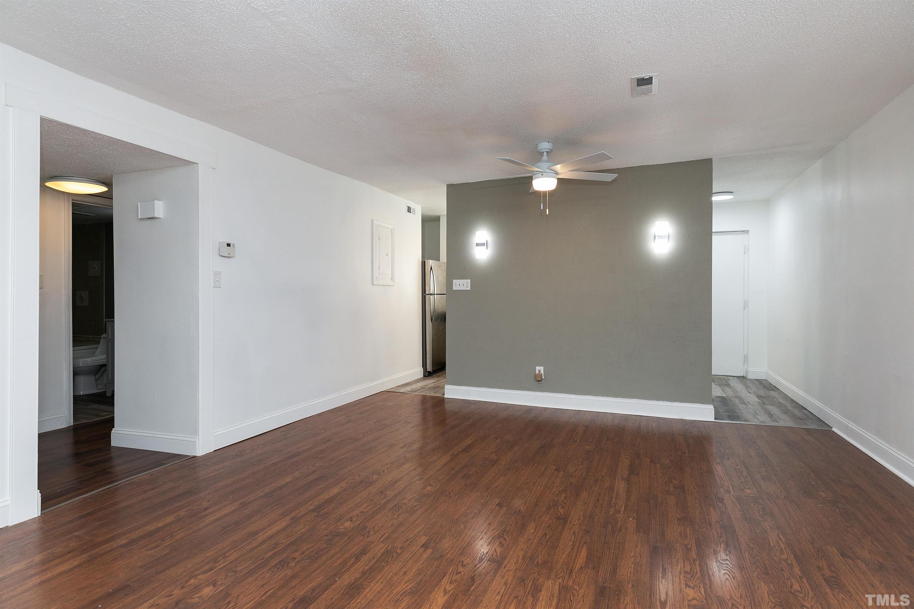 541 Pine Ridge Place, Unit 541 Raleigh, NC 27609 - Photo 6 of 21 a view of an empty room with wooden floor and a ceiling fan