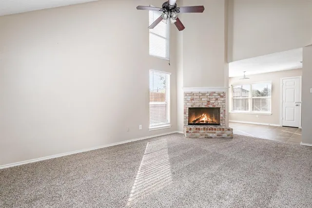 a view of an empty room with a fireplace and a window
