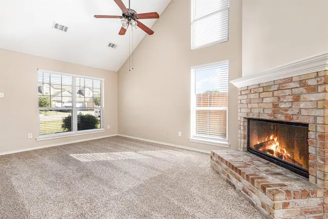 a view of an empty room with a fireplace and a window
