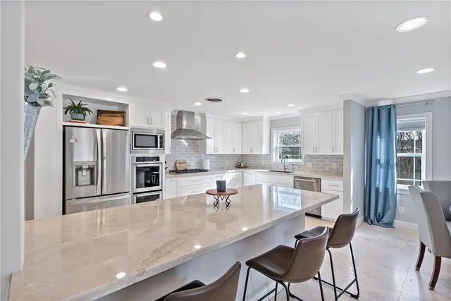 a kitchen with stainless steel appliances granite countertop a sink and refrigerator