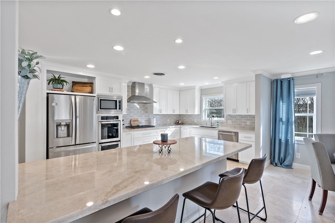 507 Crescent Drive Bryan, TX 77801 - Photo 12 of 41 a kitchen with stainless steel appliances granite countertop a sink and refrigerator