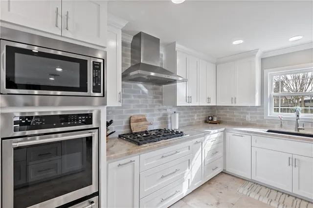 a kitchen with white cabinets and appliances