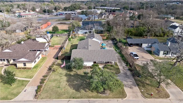 an aerial view of a house with a yard and lake view