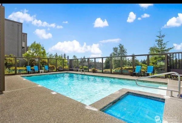 a view of a swimming pool with a patio and a yard