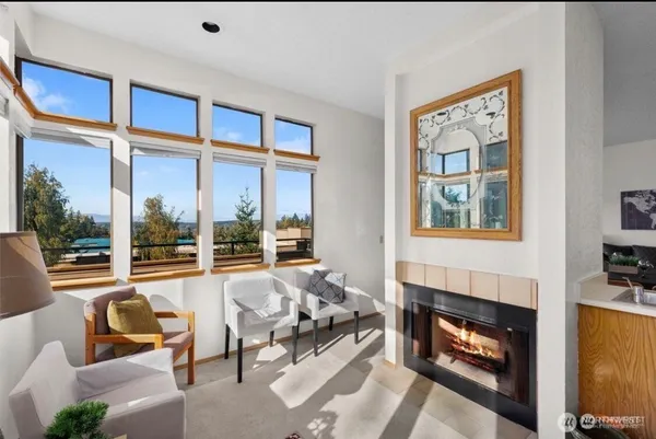 a living room with furniture a fireplace and a floor to ceiling window