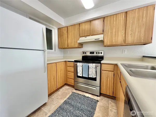 a kitchen with stainless steel appliances granite countertop a refrigerator sink and stove