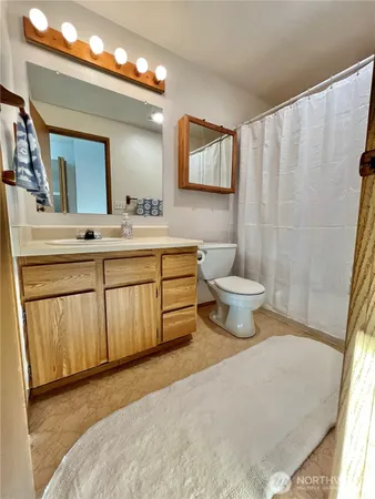 a bathroom with a sink a toilet and mirror