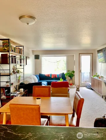 a living room with furniture a large window and a table