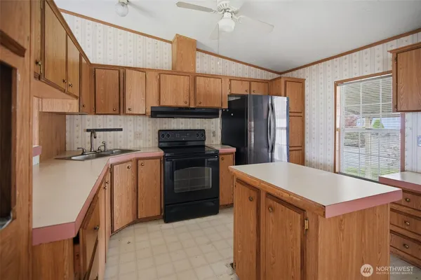 a kitchen with stainless steel appliances granite countertop a refrigerator a sink dishwasher a stove and white cabinets with wooden floor