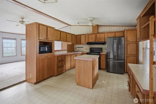 a kitchen with stainless steel appliances a refrigerator a stove a microwave a sink and cabinets