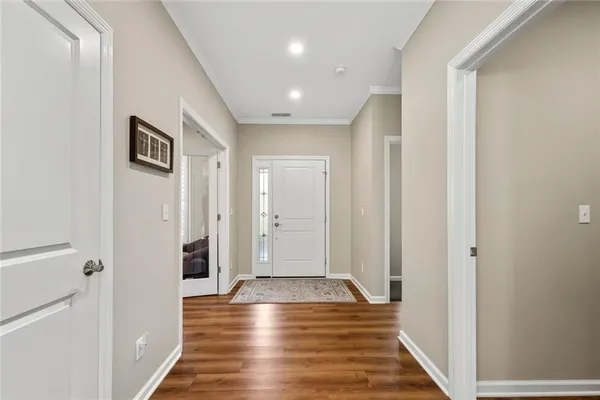 a view of a hallway with wooden floor and staircase