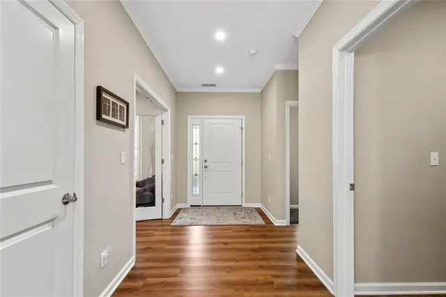 a view of a hallway with wooden floor and staircase